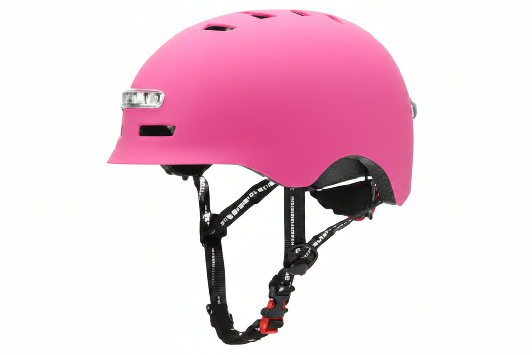 A pink skate helmet with black adjustable chin straps and a small white logo on the side, shown against a plain white background.